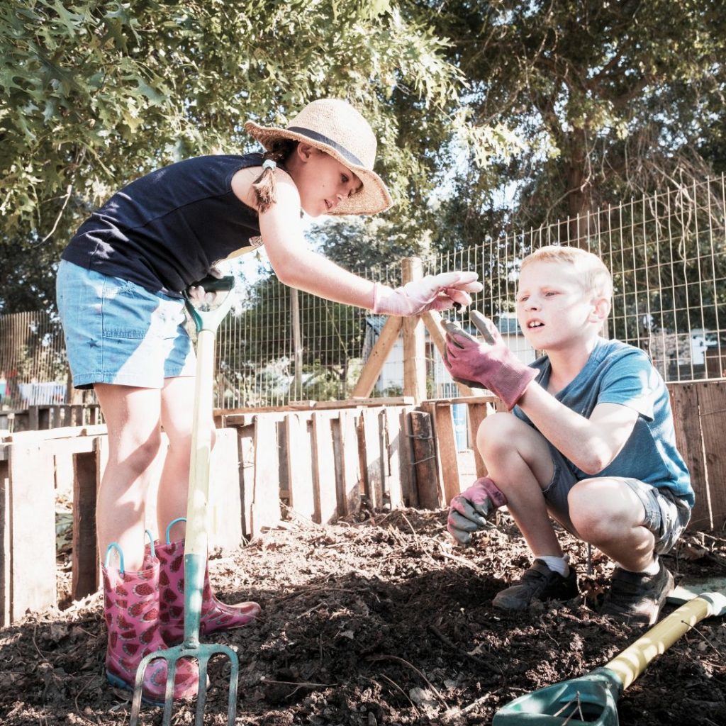 Kinder mit Regenwurm / Kompostwurm am Kompost