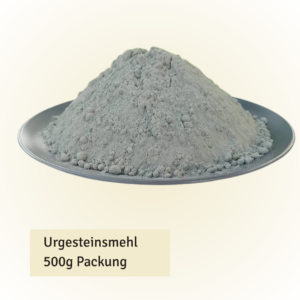 Pile of gray rock flour powder heaped on a silver plate, labeled 'Urgesteinsmehl 500g Packung'